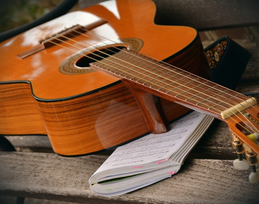 aula de violão para iniciante: violão colocado sobre um livro de cifras